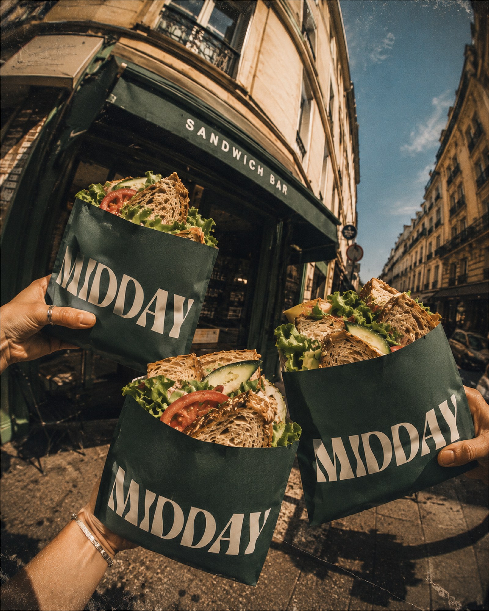 Sacs Midday tenus devant la devanture du sandwich bar à Paris